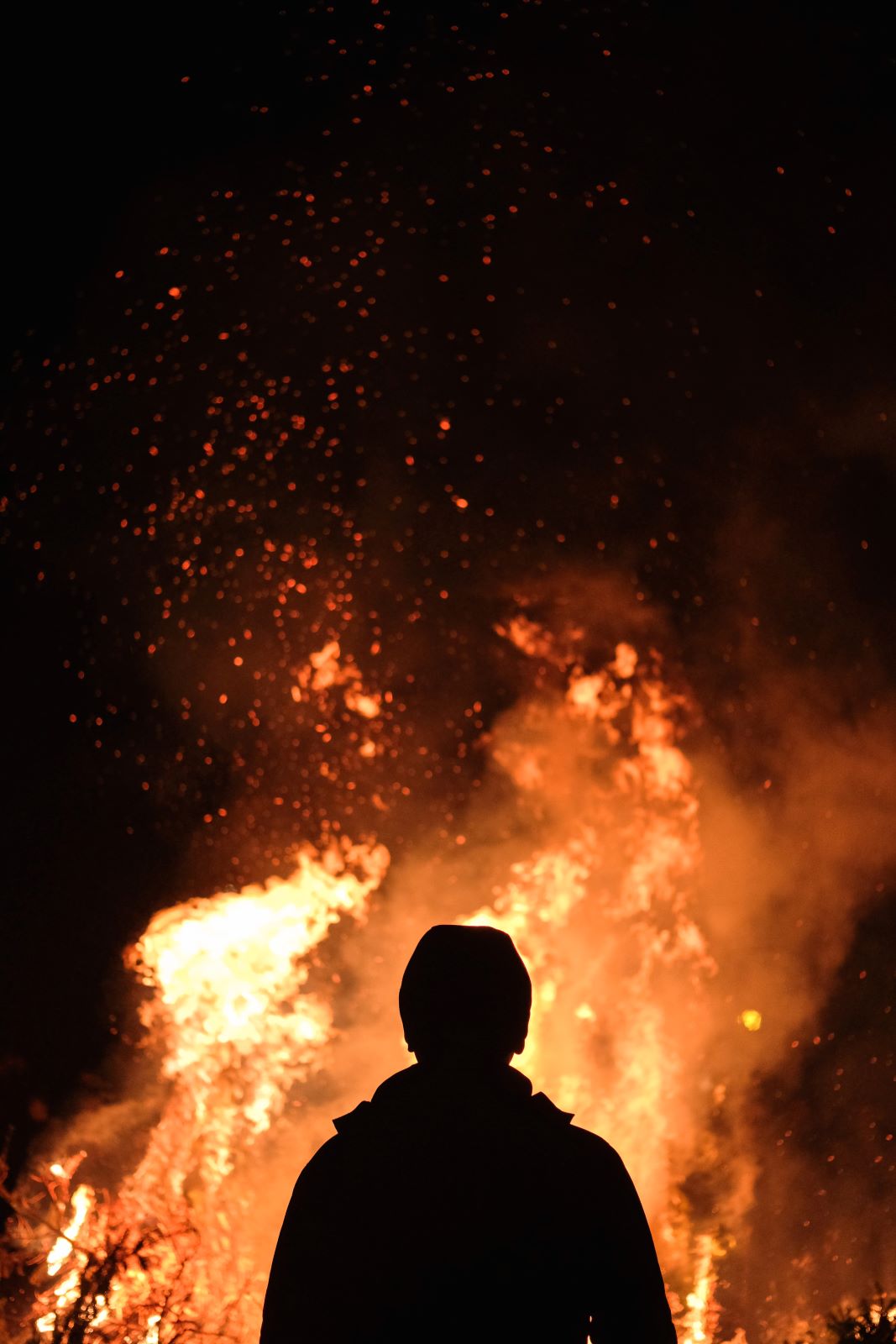 A man silhouetted by fire.